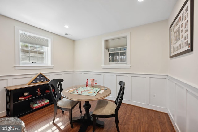 dining area with recessed lighting, a wainscoted wall, and wood finished floors