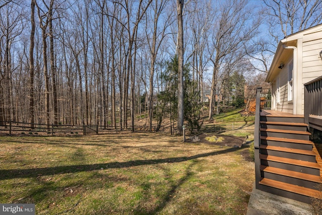 view of yard featuring a wooden deck, stairs, and fence