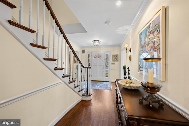 foyer featuring dark wood finished floors, stairway, baseboards, and ornamental molding