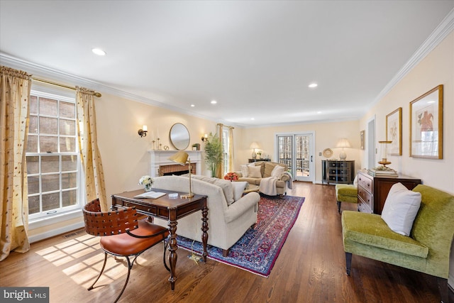 living area with wood finished floors, crown molding, recessed lighting, and a fireplace