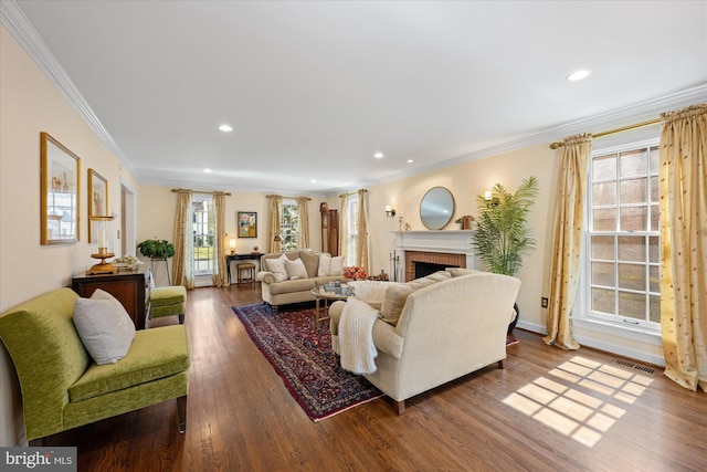 living area with dark wood-style floors, visible vents, a healthy amount of sunlight, and a fireplace