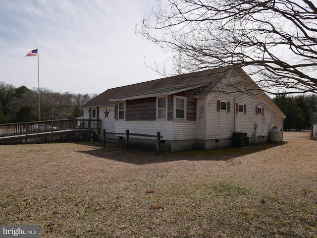 view of side of property with a deck, a lawn, central AC, and crawl space