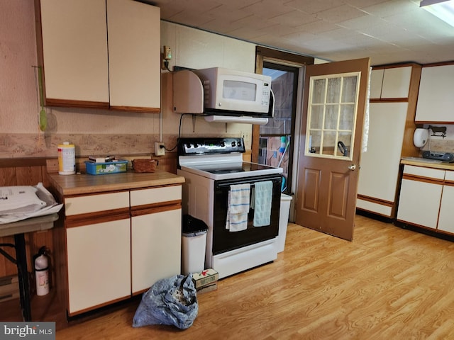 kitchen with white microwave, light countertops, range with electric stovetop, white cabinetry, and light wood-type flooring