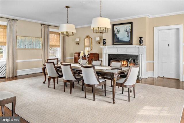 dining area with crown molding, plenty of natural light, and wood finished floors