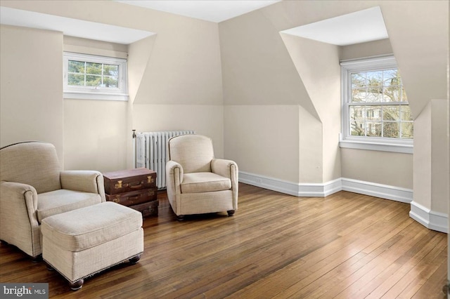 sitting room featuring hardwood / wood-style floors, radiator heating unit, and baseboards