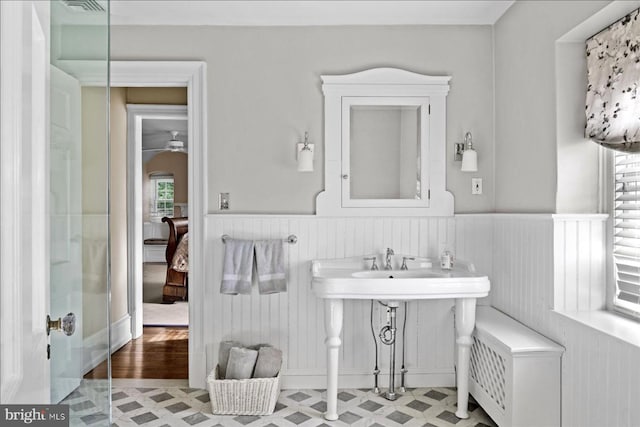 bathroom with ceiling fan, ensuite bath, wainscoting, and tile patterned floors