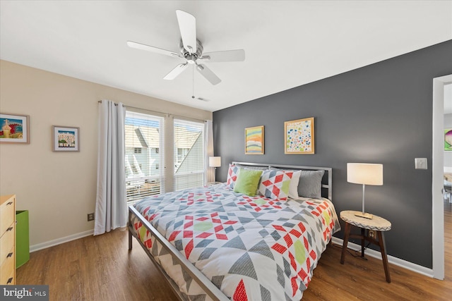 bedroom featuring wood finished floors, a ceiling fan, and baseboards