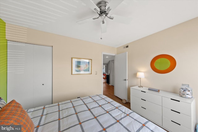 bedroom with a closet, visible vents, ceiling fan, and wood finished floors