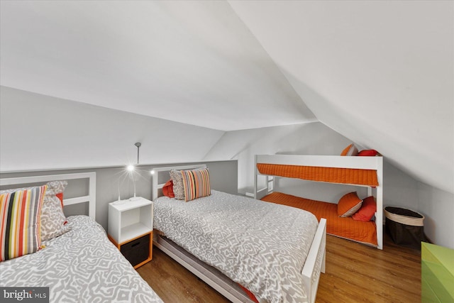 bedroom with vaulted ceiling and wood finished floors