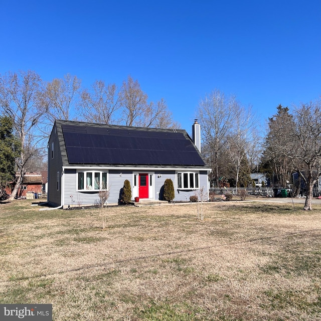 dutch colonial with a chimney, fence, a front lawn, and solar panels