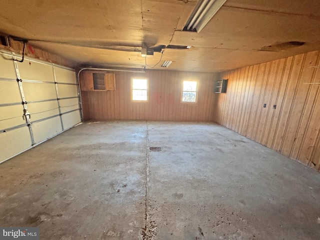 garage with a garage door opener and wooden walls