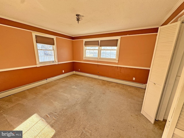 empty room with a baseboard radiator, ornamental molding, carpet flooring, a textured ceiling, and baseboards