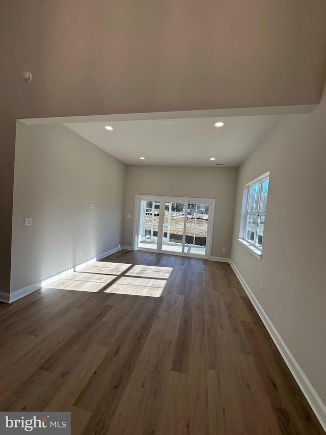 unfurnished living room with recessed lighting, baseboards, and wood finished floors