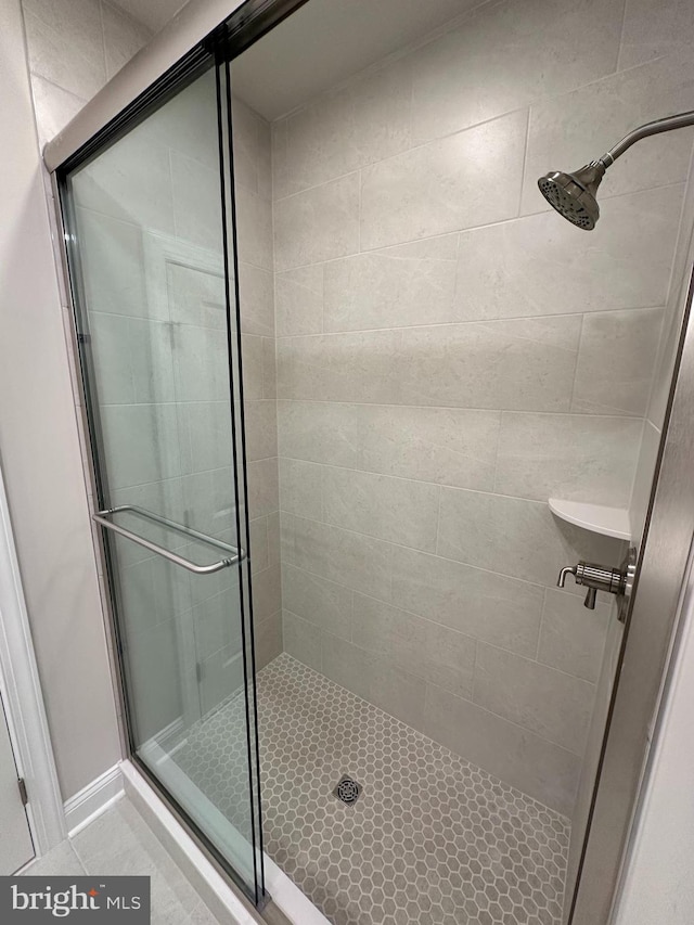 full bathroom featuring a stall shower and tile patterned flooring