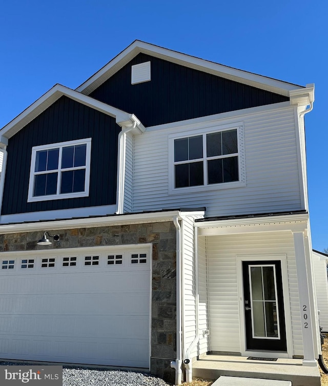 view of front of home featuring a garage and stone siding