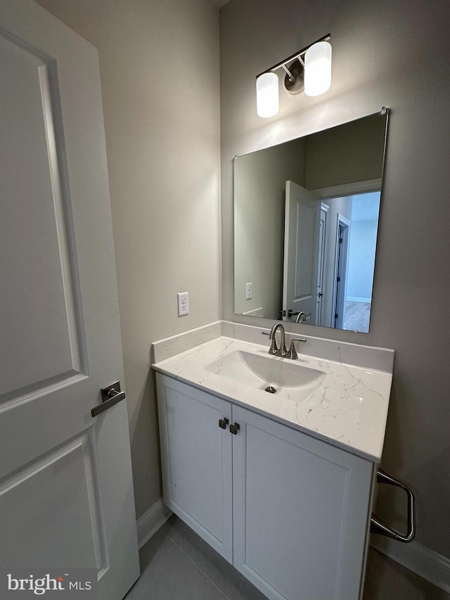 bathroom featuring tile patterned flooring, baseboards, and vanity