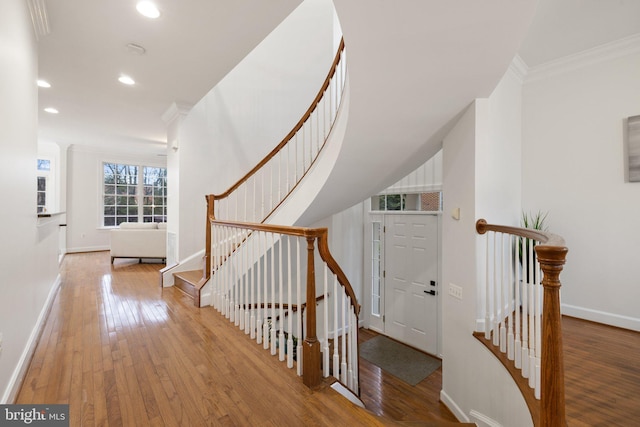 interior space featuring recessed lighting, baseboards, crown molding, and hardwood / wood-style floors