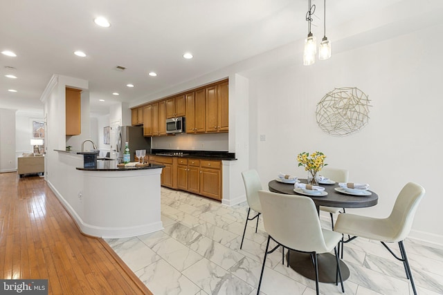 kitchen with dark countertops, marble finish floor, appliances with stainless steel finishes, and recessed lighting