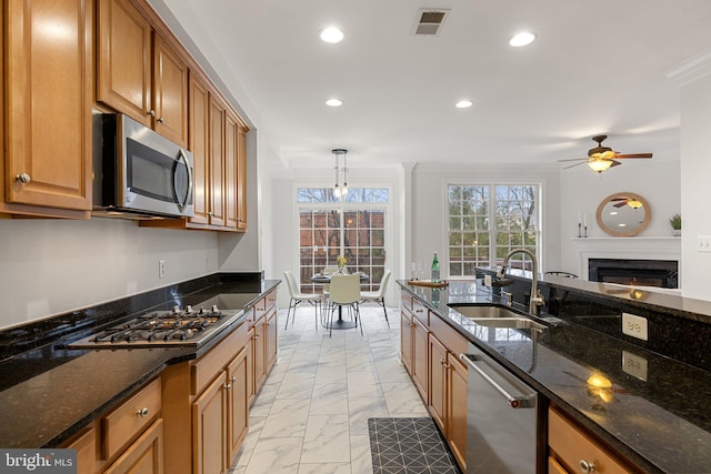 kitchen featuring marble finish floor, stainless steel appliances, recessed lighting, a sink, and a lit fireplace