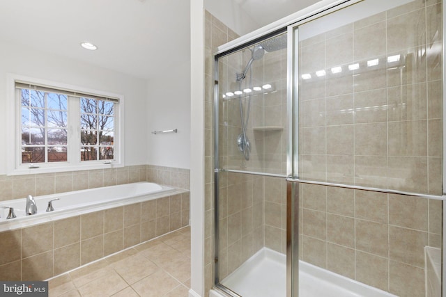 bathroom featuring a stall shower, tile patterned flooring, and a bath