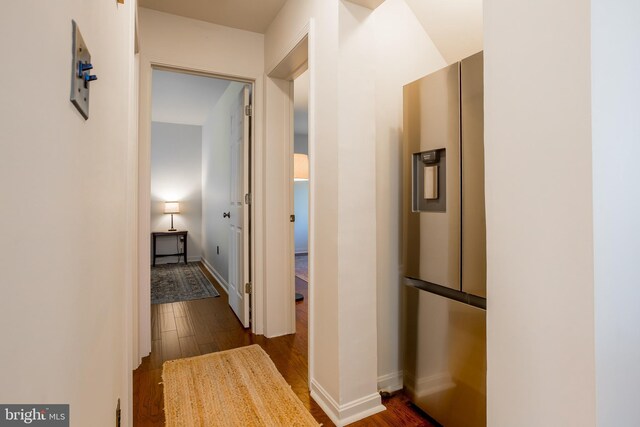 hallway featuring baseboards and dark wood-style flooring