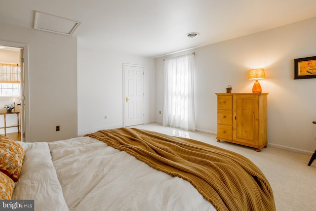 bedroom with baseboards, visible vents, light carpet, and attic access