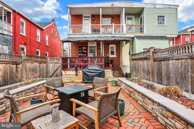 view of patio / terrace featuring a fenced backyard, a grill, and a balcony