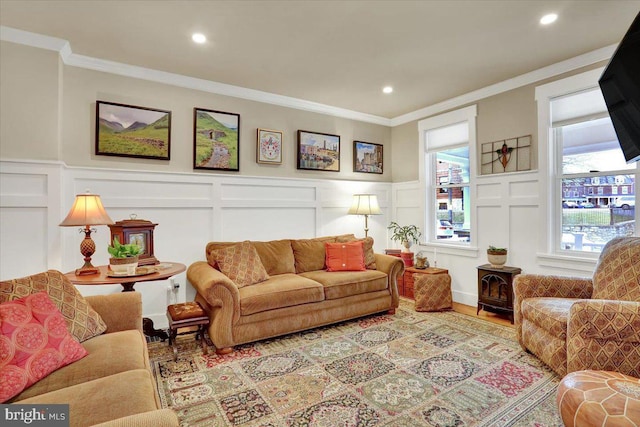 living room with a decorative wall, crown molding, and wood finished floors