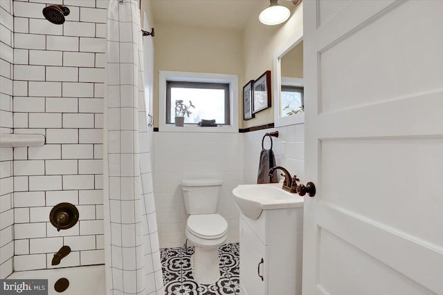 bathroom featuring tile patterned flooring, toilet, a shower with shower curtain, vanity, and tile walls