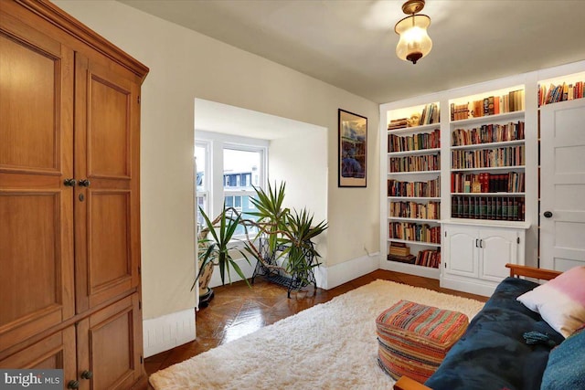 sitting room with built in features and baseboards