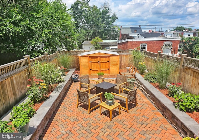 view of patio / terrace featuring a fenced backyard, an outdoor structure, and a storage shed