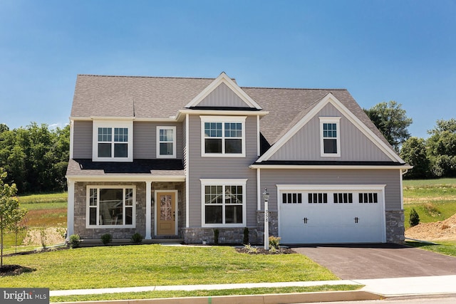 craftsman-style home with a garage, stone siding, aphalt driveway, and a front lawn