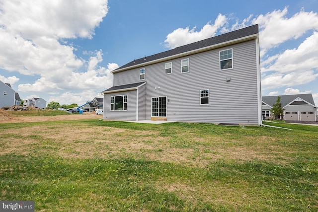 back of property featuring a patio area and a lawn