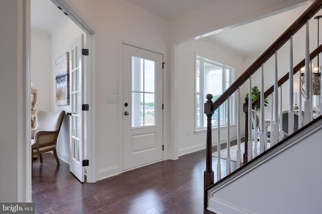 foyer featuring ornamental molding, dark wood-style flooring, stairway, and baseboards