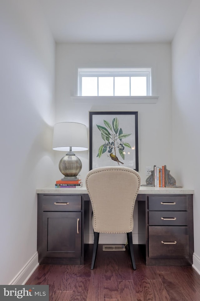 office space with dark wood-style flooring, built in study area, and baseboards