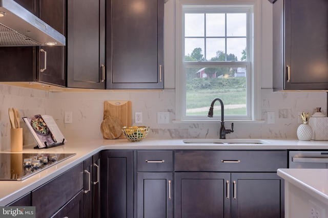 kitchen featuring under cabinet range hood, black electric stovetop, light countertops, and a sink