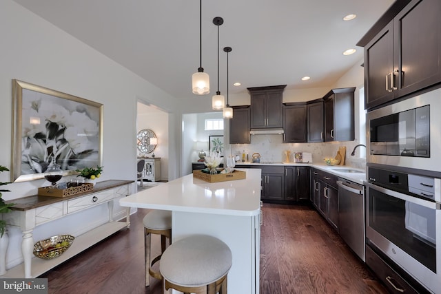 kitchen featuring a sink, built in microwave, dark wood-type flooring, and stainless steel dishwasher