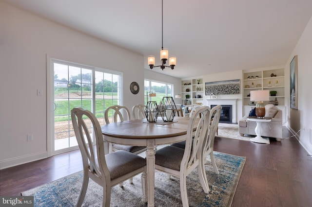 dining room featuring dark wood-type flooring, a glass covered fireplace, and baseboards