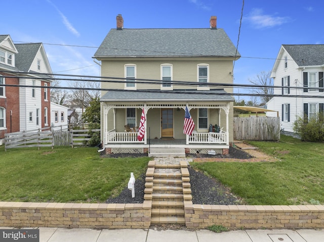 view of front facade featuring a front lawn, fence, and a porch