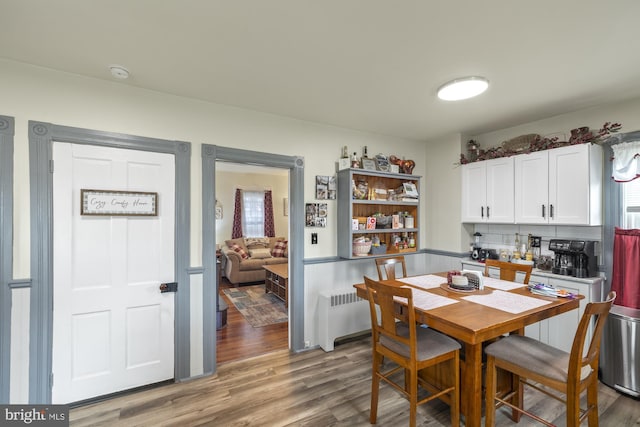 dining area featuring radiator heating unit and wood finished floors