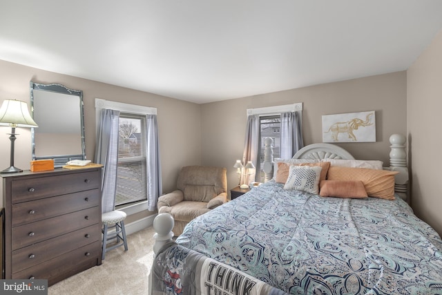 bedroom with baseboards and light colored carpet