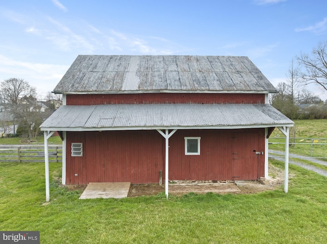 view of side of property with a detached garage, fence, a lawn, and an outdoor structure