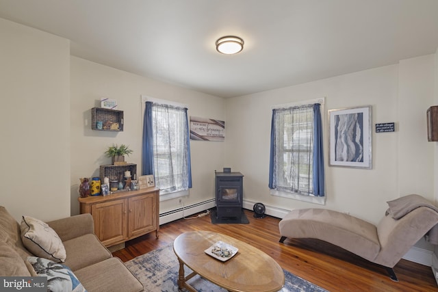 living room featuring dark wood-style floors, a baseboard heating unit, a baseboard radiator, and a wood stove