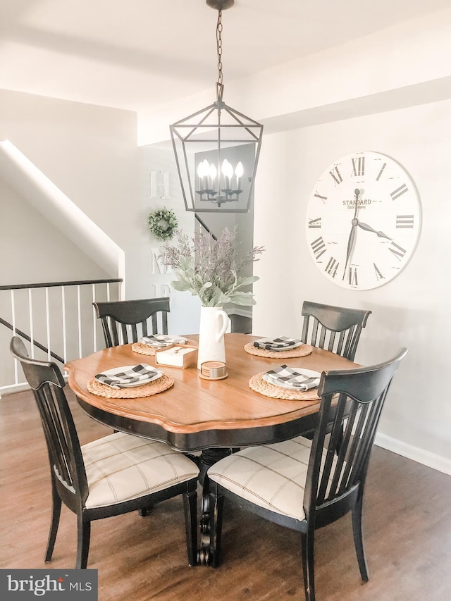 dining area with an inviting chandelier, baseboards, and wood finished floors