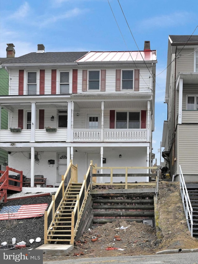 view of front of property featuring a chimney and stairway