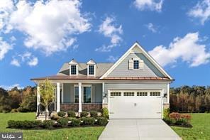 craftsman-style home with a garage, concrete driveway, a porch, and a front yard