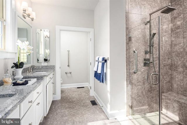 bathroom featuring visible vents, toilet, a shower stall, vanity, and baseboards