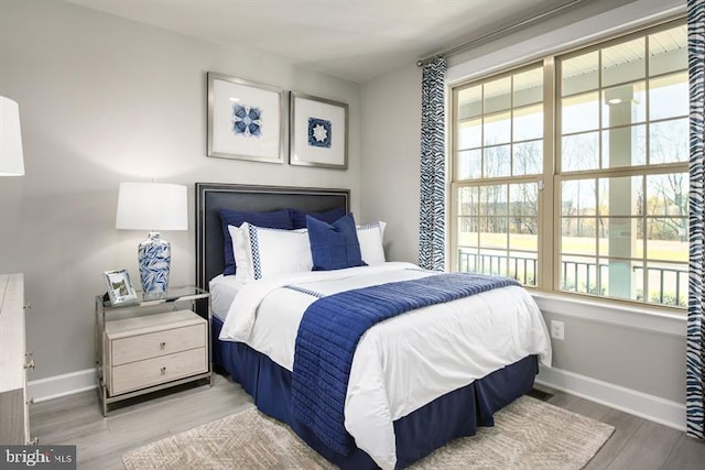 bedroom with wood finished floors and baseboards