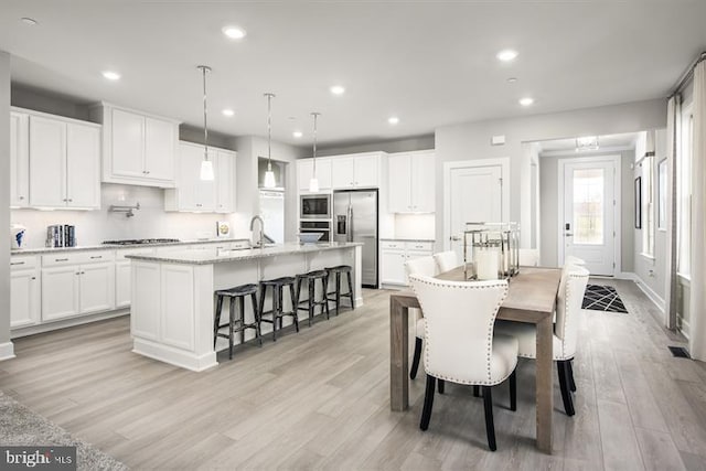 dining space with recessed lighting and light wood-style flooring