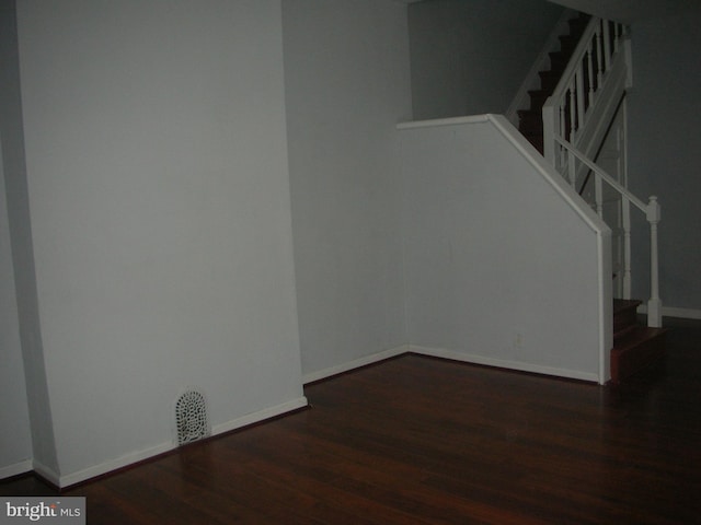 unfurnished room featuring stairway, baseboards, and wood finished floors